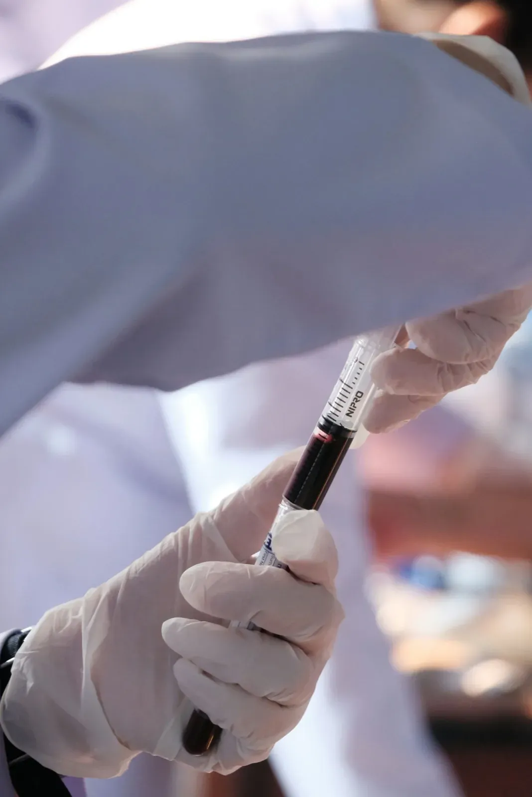 A person in white gloves is holding a syquet